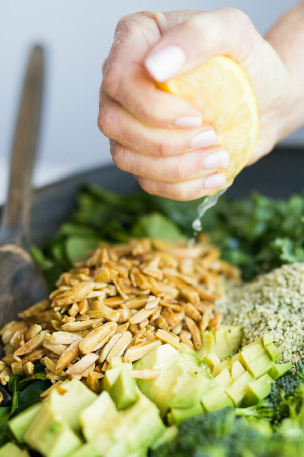 chopped green salad with lemon being squeezed